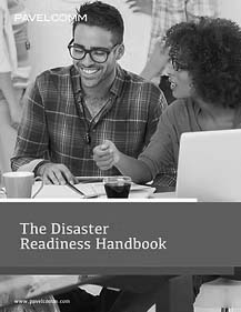 861ec6_73639110dc18422b8fe77ece58a72a57mv2 Two people sit at a table, smiling and talking while looking at documents about Disaster Recovery. A coffee mug and laptop are in front of them. The cover text reads “The Disaster Readiness Handbook.”.