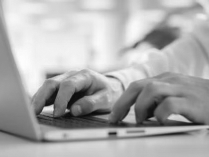 Close-up of a person's hands typing on a laptop keyboard, focused on data cleaning tasks, with a blurred background and a hint of greenery.